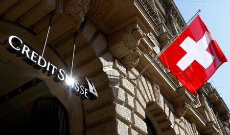 Switzerland's national flag flies beside the logo of Swiss bank Credit Suisse in Zurich, Switzerland April 24, 2017.  REUTERS/Arnd Wiegmann