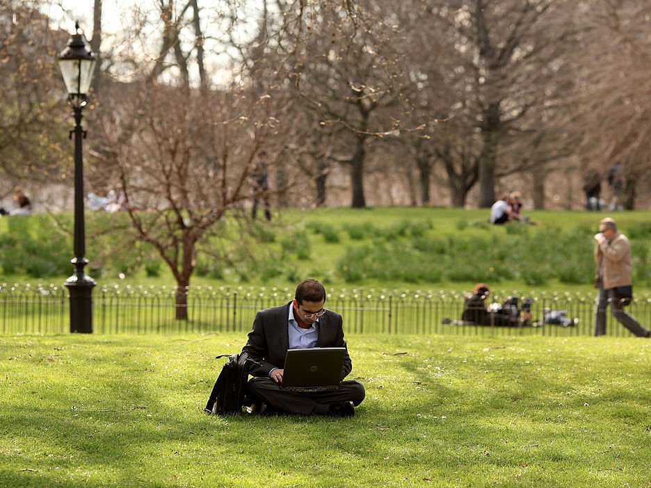 man working computer laptop outside park work from home business