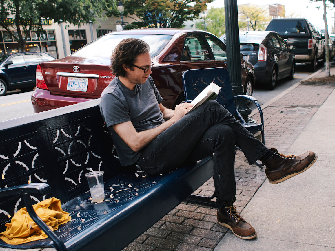 man reading on bench