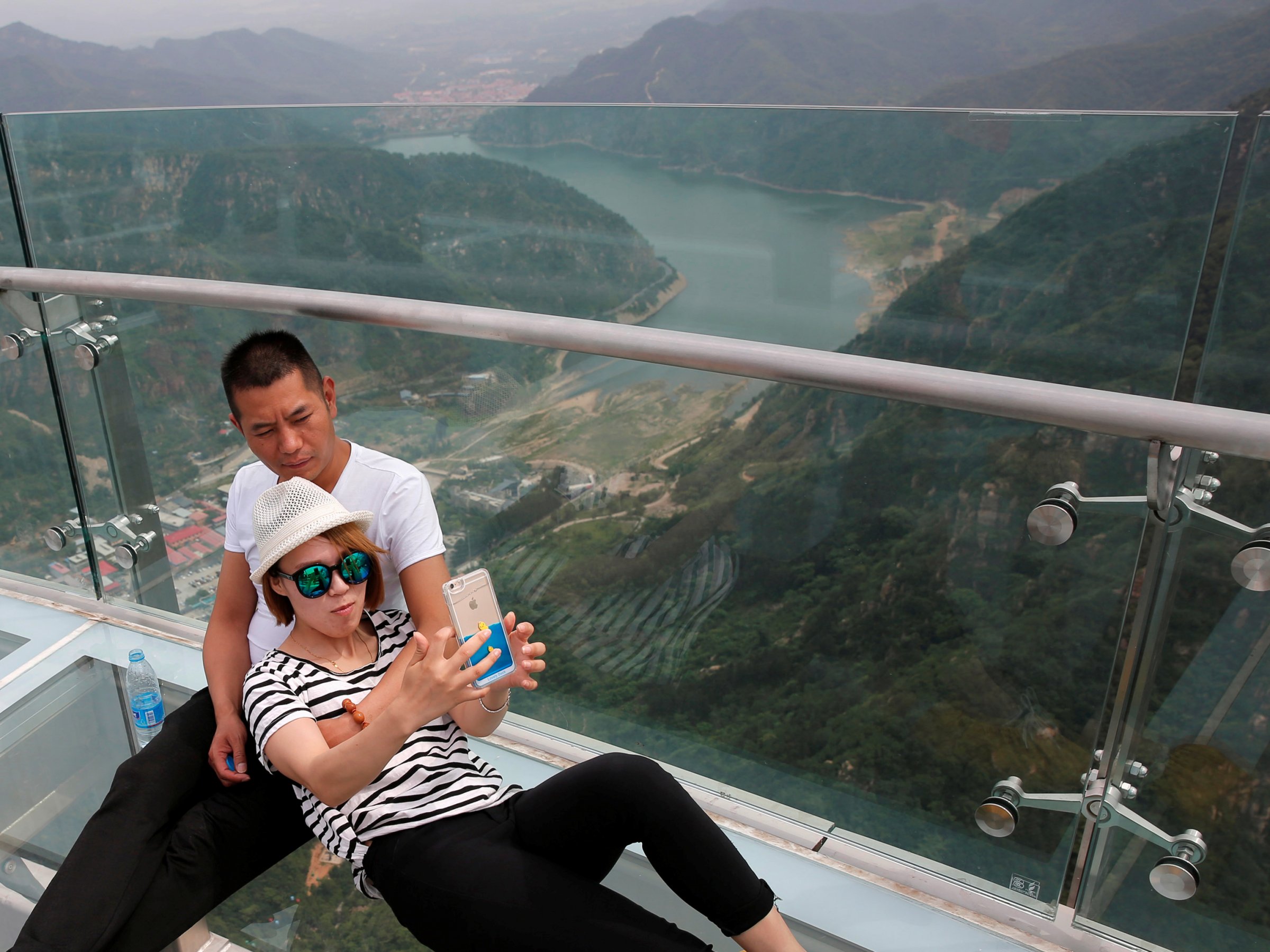 A couple takes a selfie on the glass sightseeing platform on Shilin Gorge in Beijing, China, May 27,