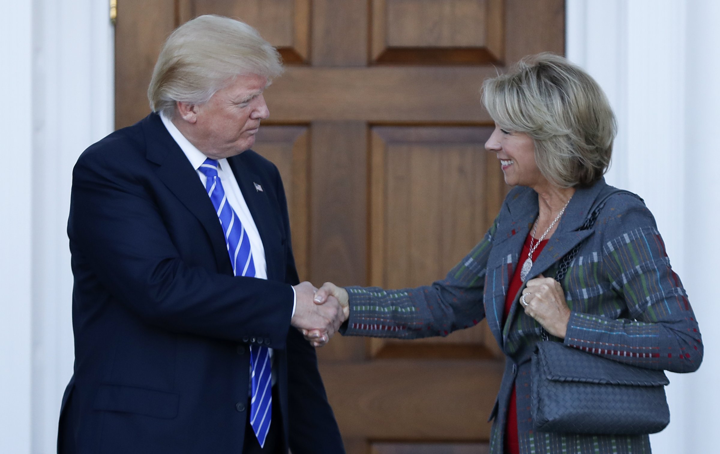 President-elect Donald Trump and Betsy DeVos shake hands at Trump National Golf Club Bedminster clubhouse in Bedminster, N.J., Saturday, Nov. 19, 2016.