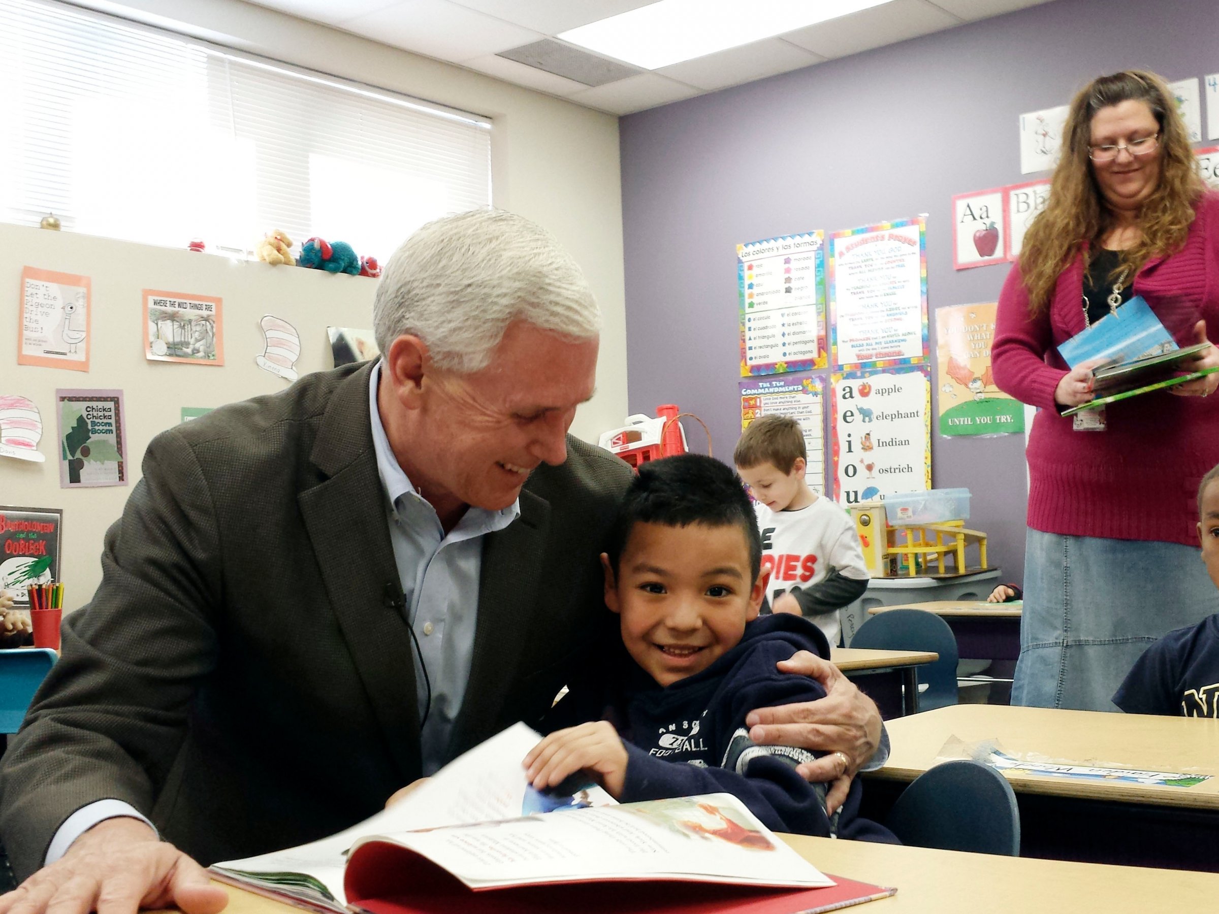 Gov. Mike Pence embraces a preschool student at the Shepherd Community Center Wednesday, Feb. 26, 2014, in Indianapolis. Pence has had trouble winning support from lawmakers for his proposed preschool voucher program. (AP Photo/Tom LoBianco)