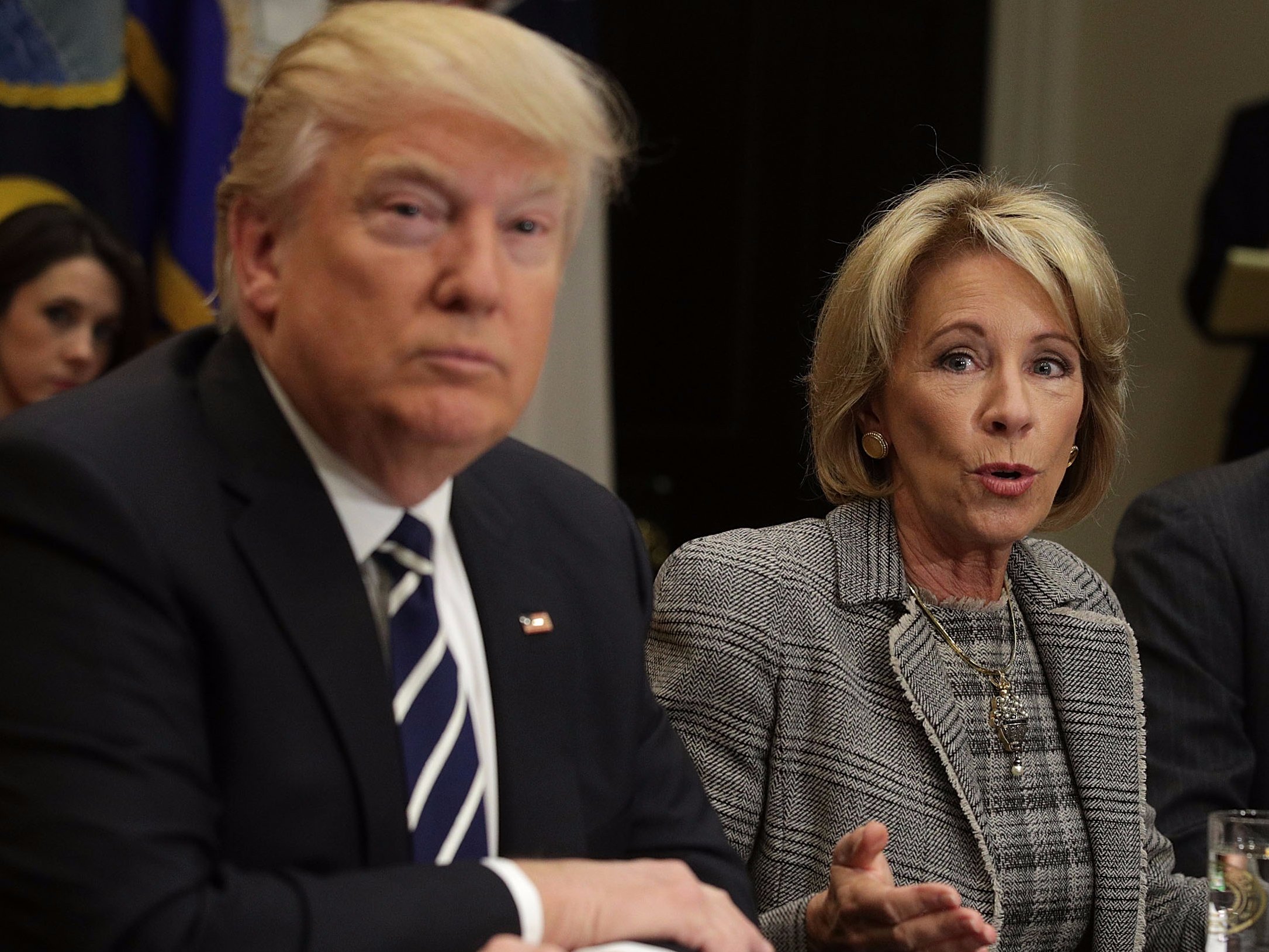 WASHINGTON, DC - FEBRUARY 14: U.S. Secretary of Education Betsy DeVos (C) speaks as President Donald Trump (L) and educator Kenneth Smith (R) listen during a parent-teacher conference listening session at the Roosevelt Room of the White House February 14, 2017 in Washington, DC. The White House held the session to discuss education.