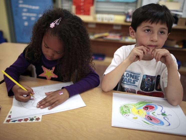 Aniya Cope (L) and Ryan Goss, 5, color Chinese masks at Broadway Elementary School in Venice, Los Angeles, California, April 11, 2011. REUTERS/Lucy Nicholson  